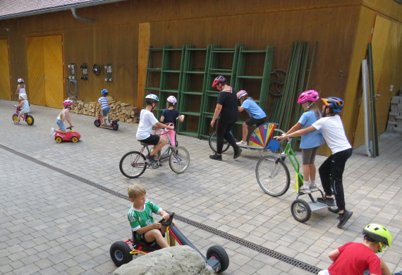 Spaß- und Geschicklichkeitsräder zum Ausprobieren, auf diesem Bild sind viele Kinder mit Freude dabei